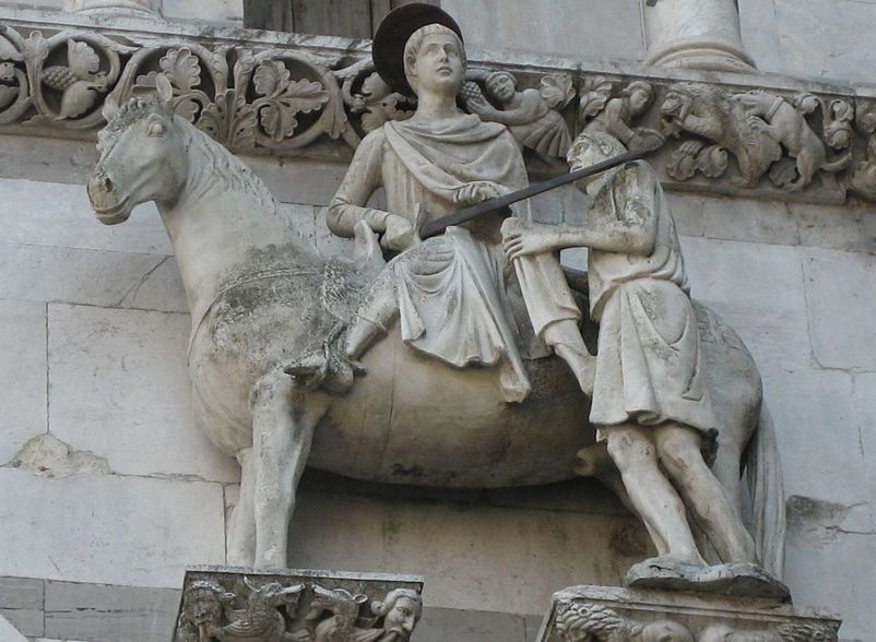 Representação tradicional mais frequente de São Martinho, cortando seu manto para dividi-lo com um pobre. Pormenor da fachada da catedral de São Martinho, em Lucca (Itália)