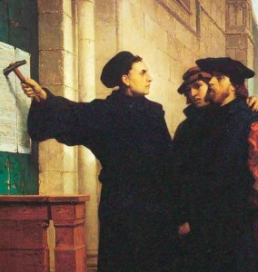 Figura do apostata Lutero, expondo suas "teses" na Alemanha, berço de sua revolta.